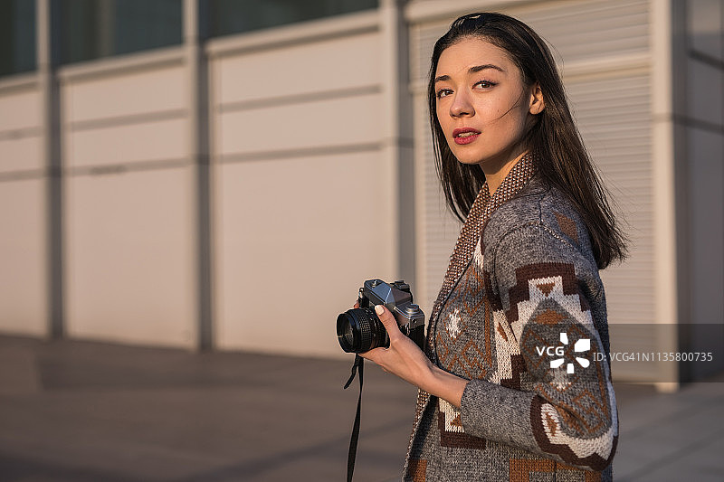 手持照相机的迷人女孩图片素材