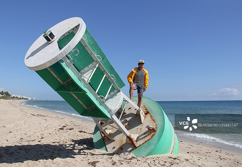 站在搁浅大型浮标航道标志上的船长图片素材
