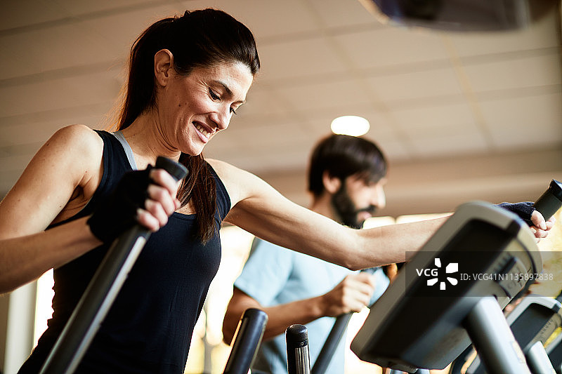 巴塞罗那健身房生活方式，人们在椭圆机上锻炼图片素材