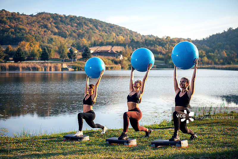 在湖边用球锻炼的女人图片素材
