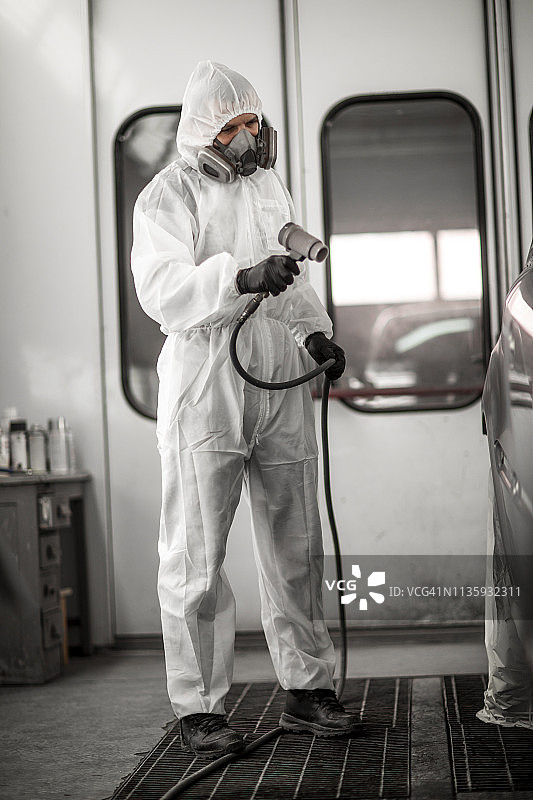 汽车喷漆技师使用气动干燥机干燥车厢喷漆图片素材