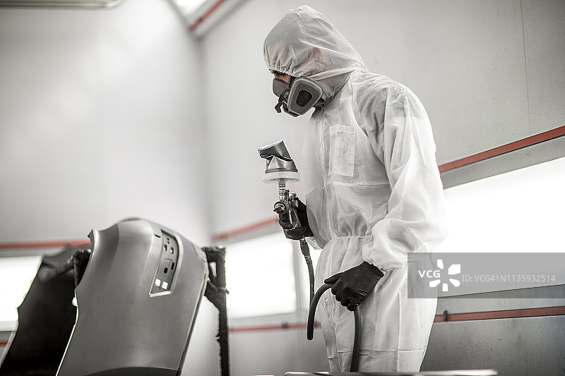 汽车修理厂：喷漆技师修复交通意外受损的汽车保险杠图片素材