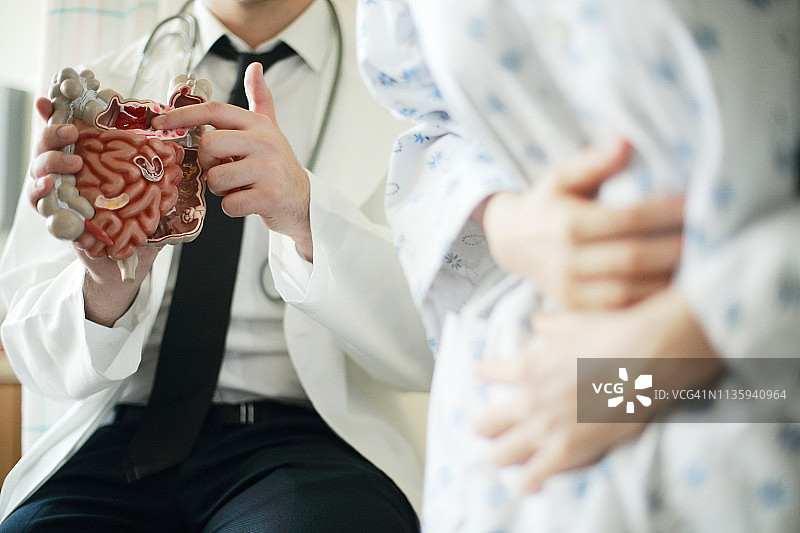 医生在办公室向病人展示肠道模型图片素材