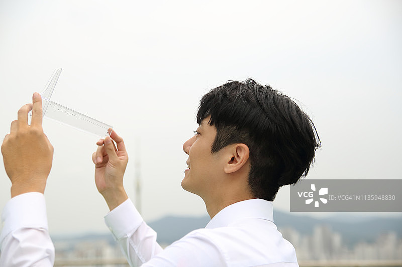 户外看T型尺的商人图片素材