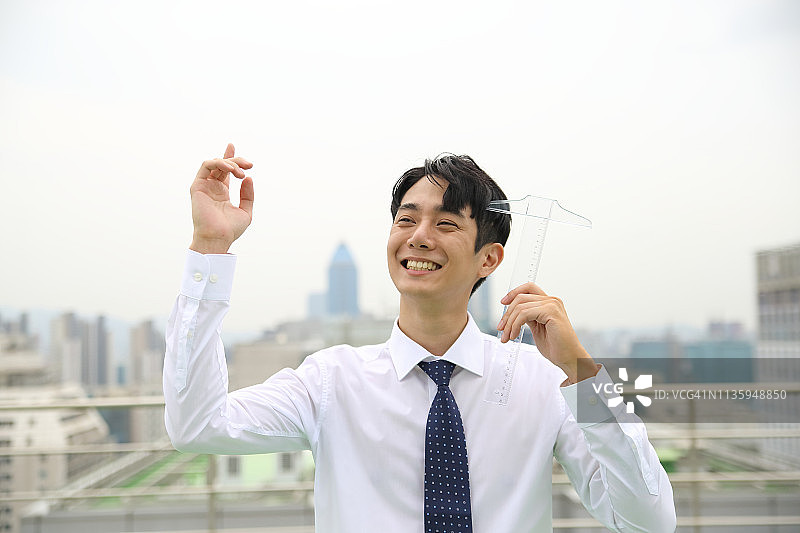 商人在屋顶上手持丁字尺图片素材