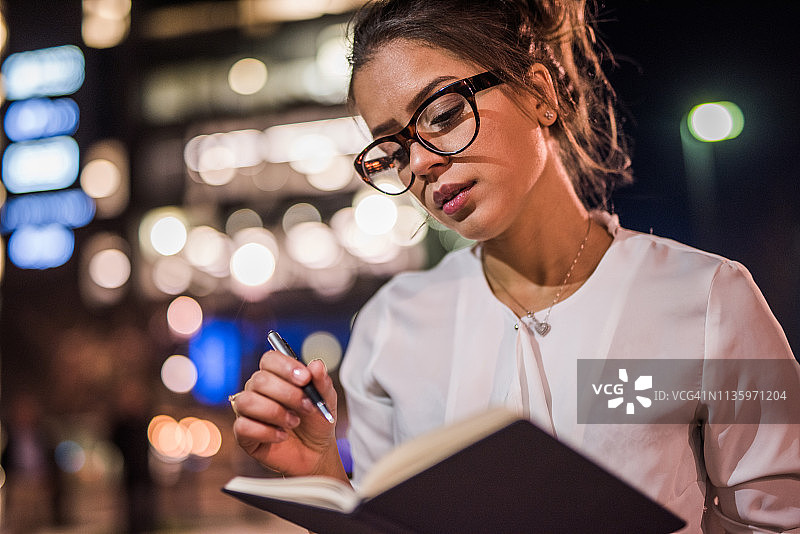 漂亮的女学生在考试前夜复习笔记图片素材