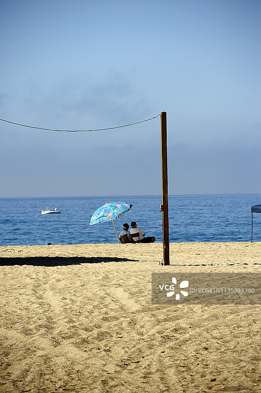 一对老年夫妇坐在美国加利福尼亚州穆古角海滩图片素材