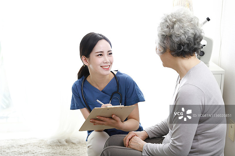 护士填写表格并与年长患者交谈图片素材