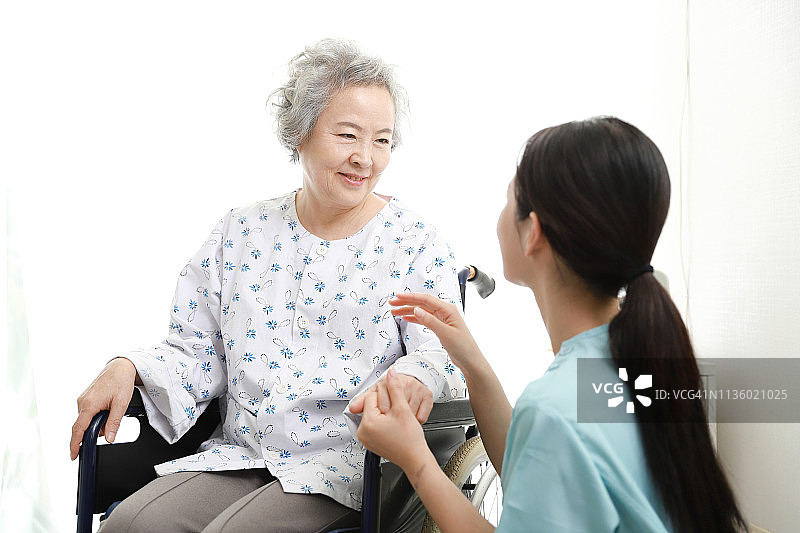 护士与坐轮椅的老年妇女交谈图片素材