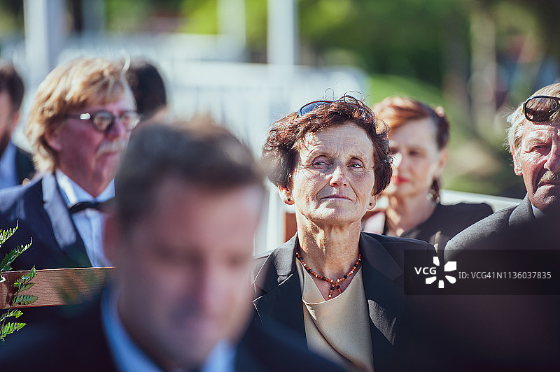 年长女人坐在婚礼上四处张望图片素材