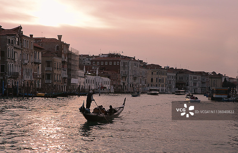 日落时分在意大利威尼斯大运河上划桨的贡多拉船夫图片素材