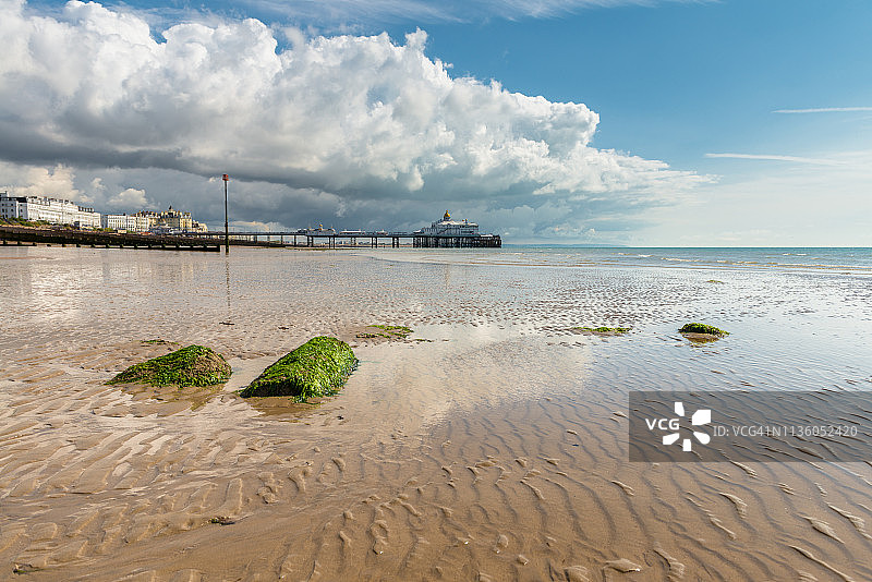 东萨塞克斯郡伊斯特本码头及其退潮沙滩上的暴风云图片素材