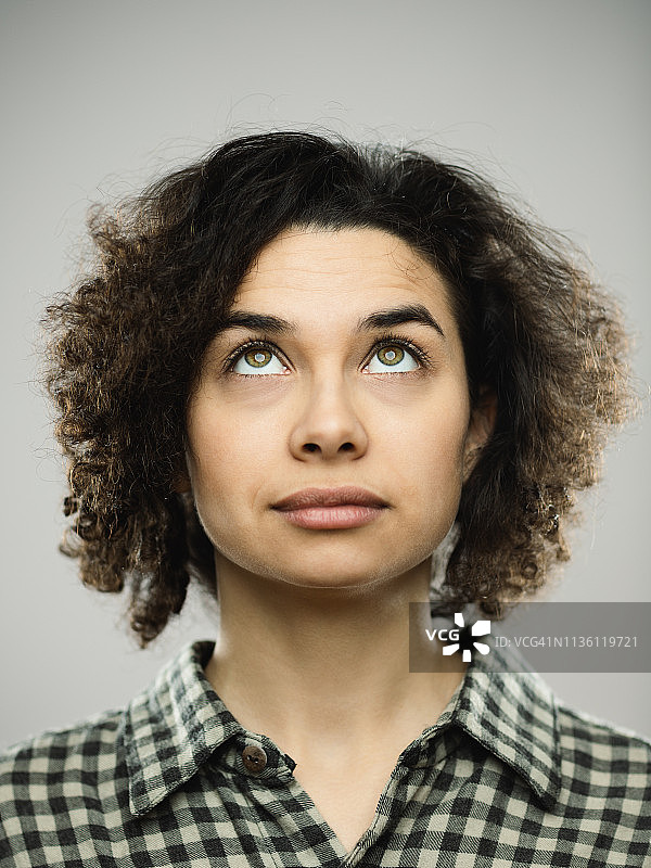 面无表情向上看的年轻女性影棚肖像图片素材