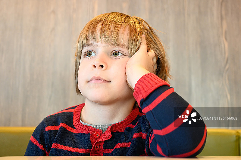 餐厅里等待用餐的小男孩（6岁）特写图片素材