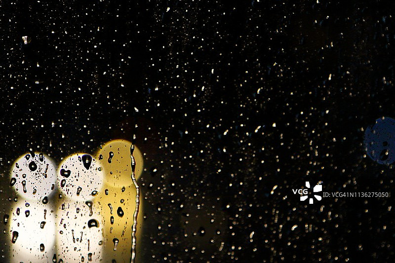 雨中玻璃上的车辆虚化灯光图片素材