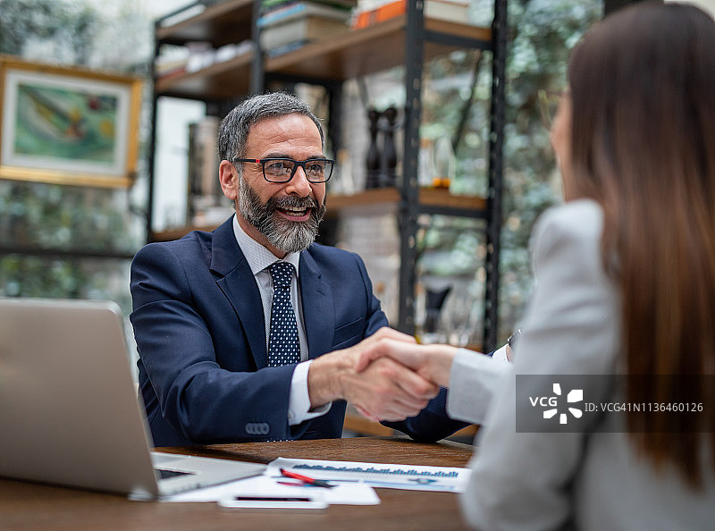 行政人员在咖啡店握手图片素材