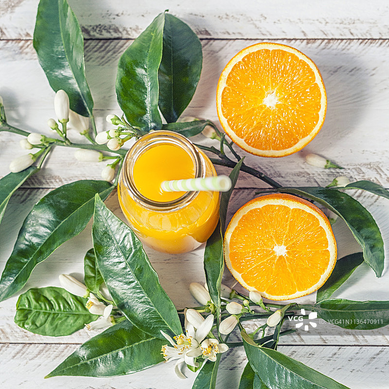乡村白色木质背景上的新鲜橙子和瓶装橙汁图片素材