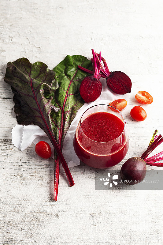 甜菜根汁和新鲜甜菜根，生甜菜和番茄的排毒纯素冰沙图片素材