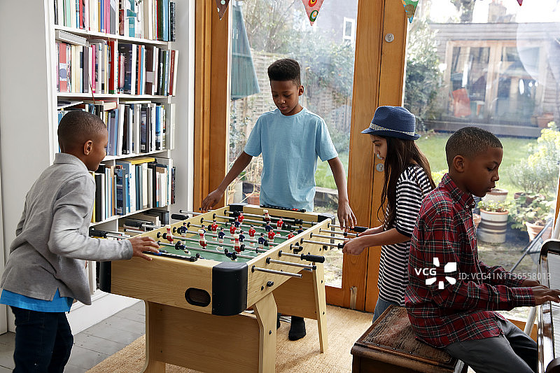 孩子们在家玩桌上足球放松图片素材