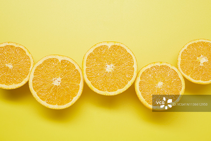 黄色背景上的橙子切片静物图片素材