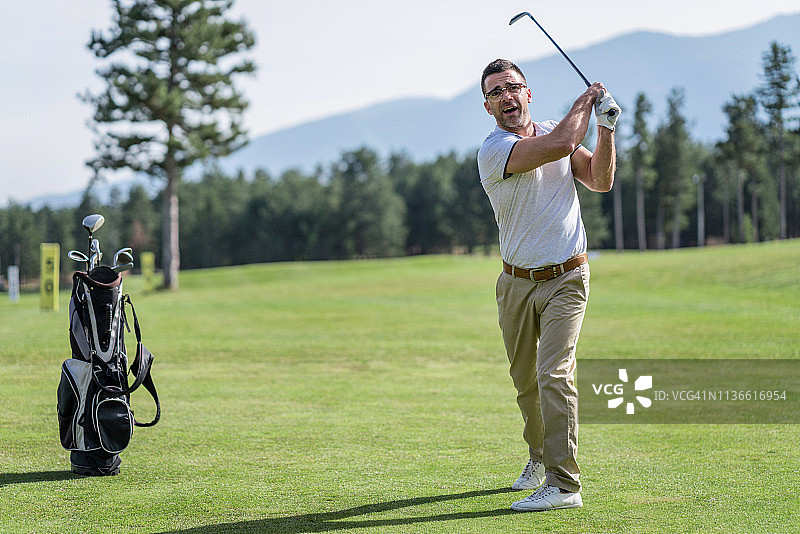 成年男子在高尔夫球场开球图片素材