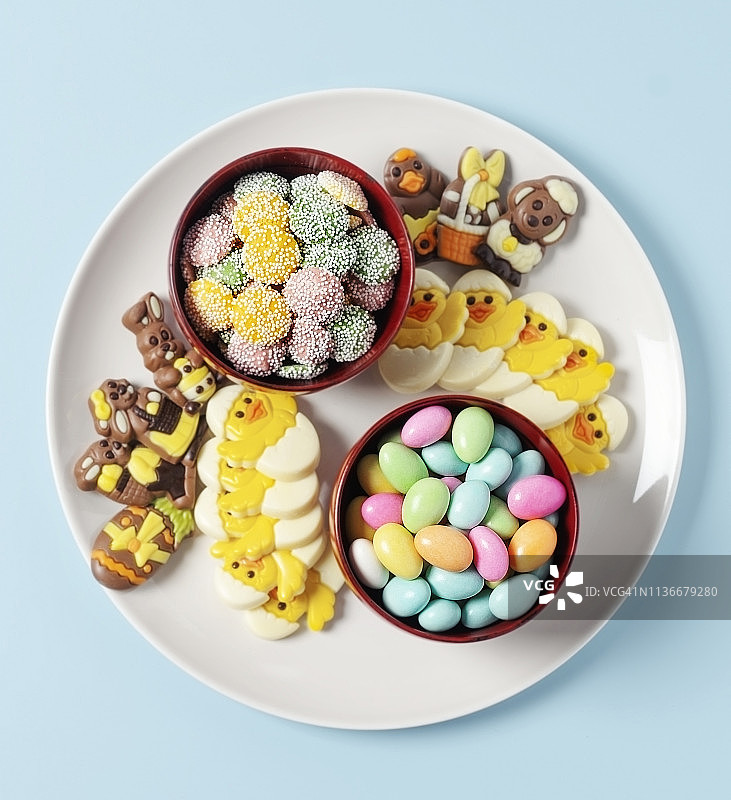 蓝色背景盘中各种复活节巧克力和糖果图片素材