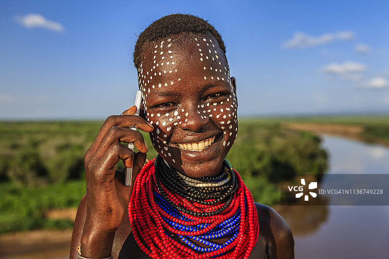 使用智能手机的卡罗部落年轻女孩，埃塞俄比亚，非洲图片素材