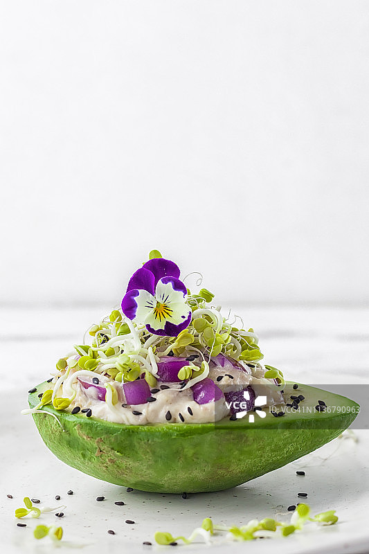 金枪鱼牛油果花园，配蛋黄酱、红洋葱、黑芝麻、萝卜苗和食用花卉（三色堇）图片素材