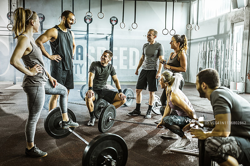健身房休息时交谈的快乐运动员朋友图片素材