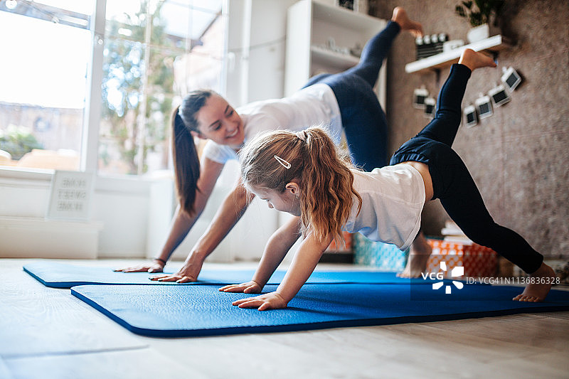 母亲和女儿在家一起锻炼图片素材