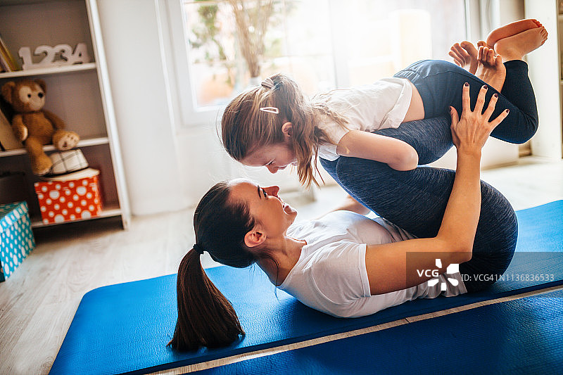 母亲和女儿在家一起锻炼图片素材