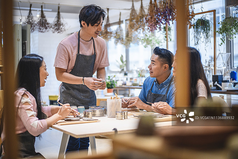 男老师在陶艺课上给学生讲解图片素材