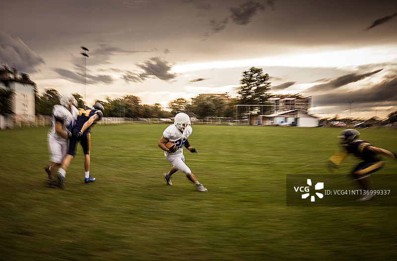 在模糊的运动中进行比赛的美式橄榄球运动员图片素材