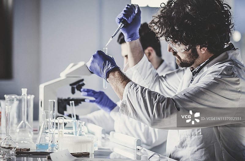 在实验室工作的科学家，使用移液管图片素材