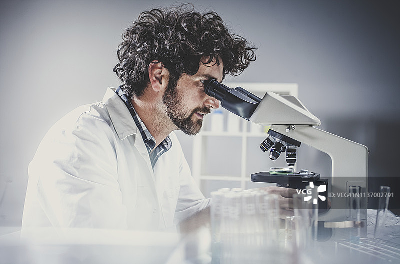 科学家在实验室工作，使用显微镜图片素材