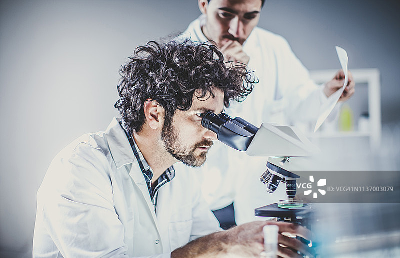 科学家在实验室使用显微镜工作图片素材