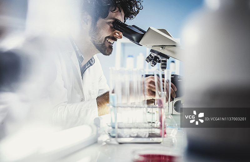 科学家在实验室工作，使用显微镜图片素材