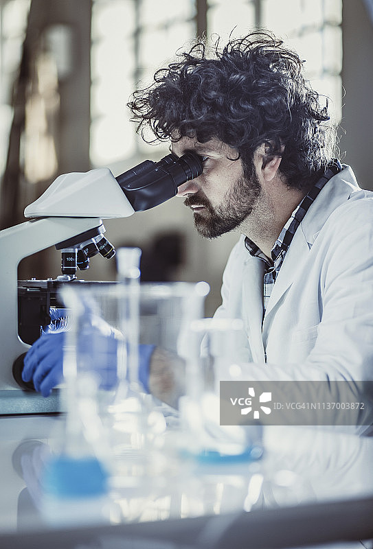 科学家在实验室工作，使用显微镜图片素材