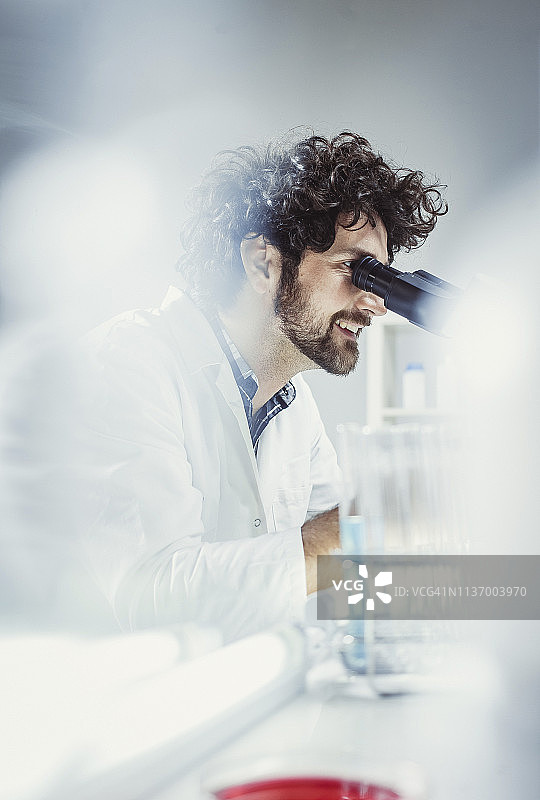 科学家在实验室工作，使用显微镜图片素材