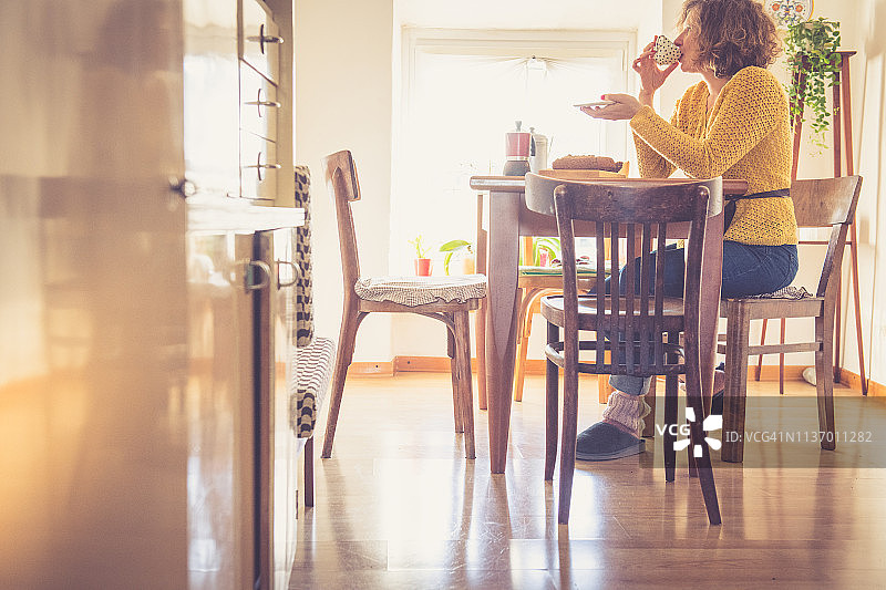 年轻女人在厨房吃早餐图片素材