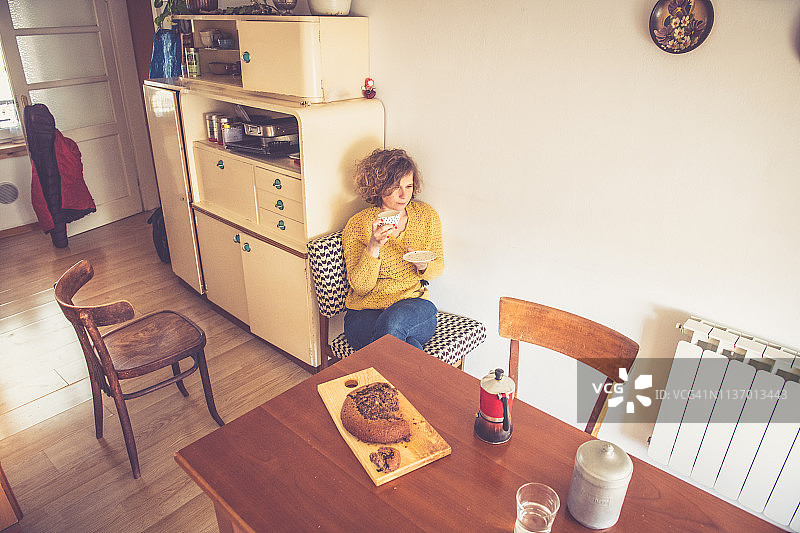年轻女人在厨房吃早餐图片素材