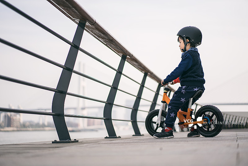 戴着运动头盔骑自行车的小男孩肖像图片素材