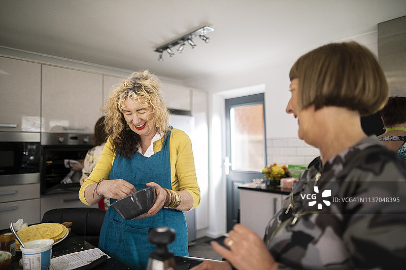 和朋友在厨房里添加食材！图片素材