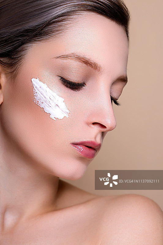 脸上涂着面霜的美女向下看特写图片素材