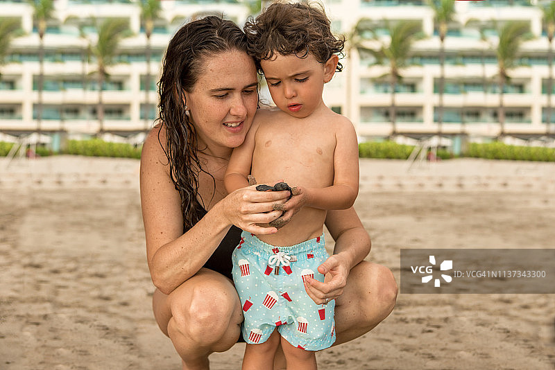男孩们在海滩放生海龟图片素材