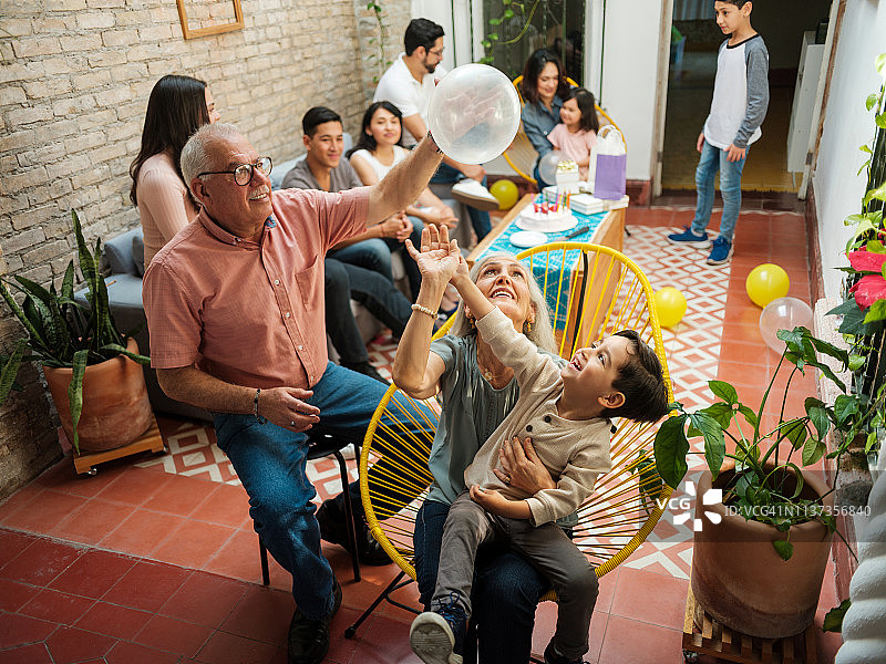 快乐的墨西哥祖父母和孙子玩气球图片素材