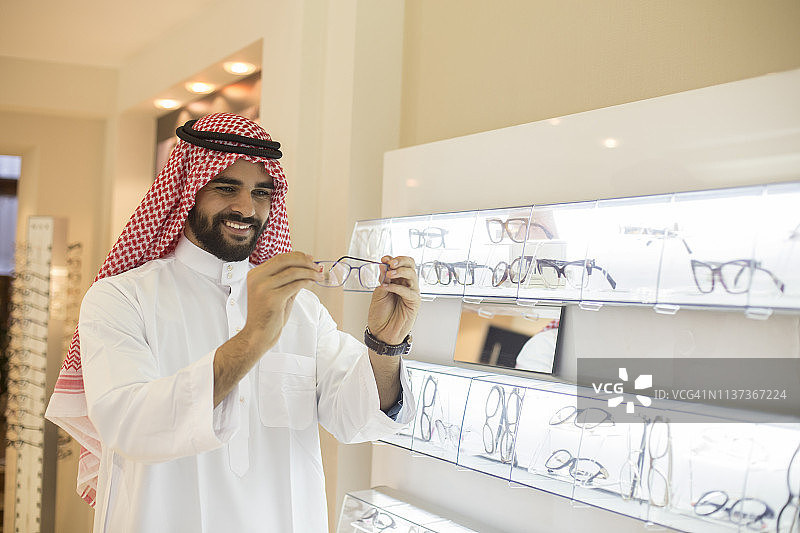 阿拉伯男人在商店挑选眼镜图片素材