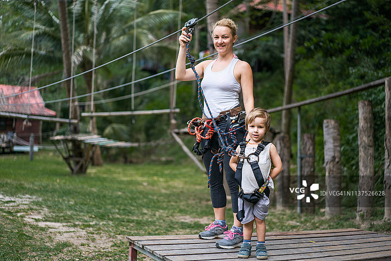 快乐的母亲和小儿子在自然环境中体验树冠之旅图片素材