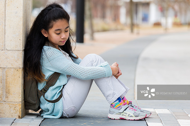 在学校外等待接送的小学年龄女孩图片素材