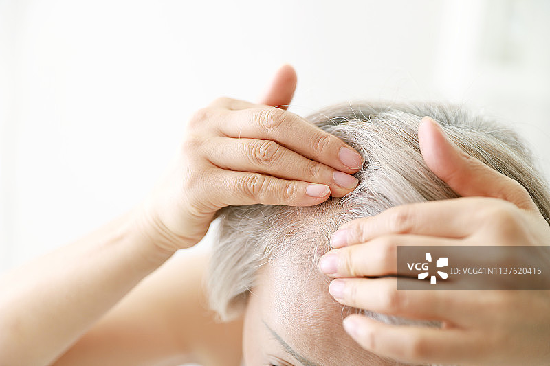 年长妇女检查头发的特写图片素材